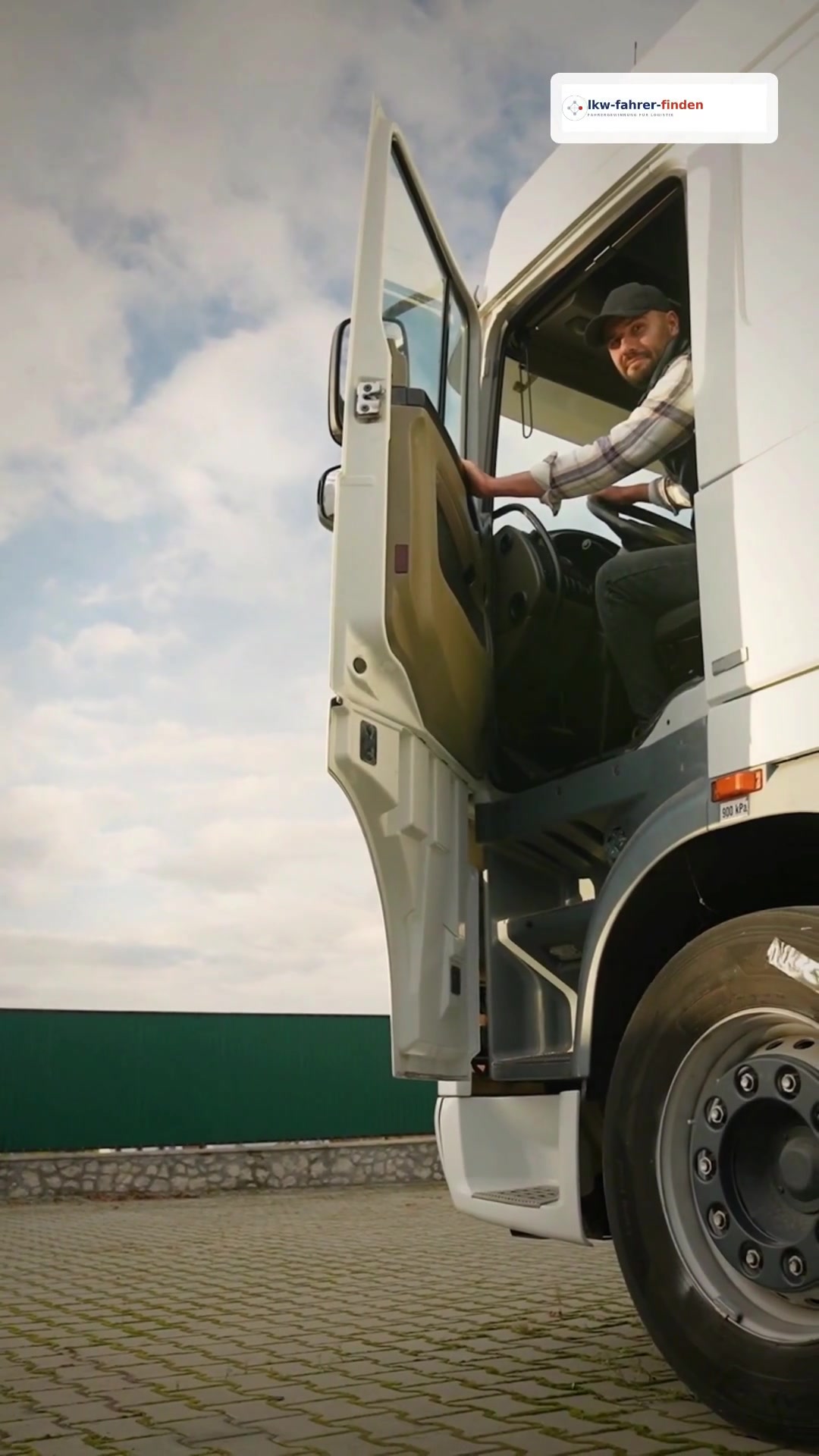 LKW-Fahrer am geöffneten Führerhaus eines weißen Lastwagens